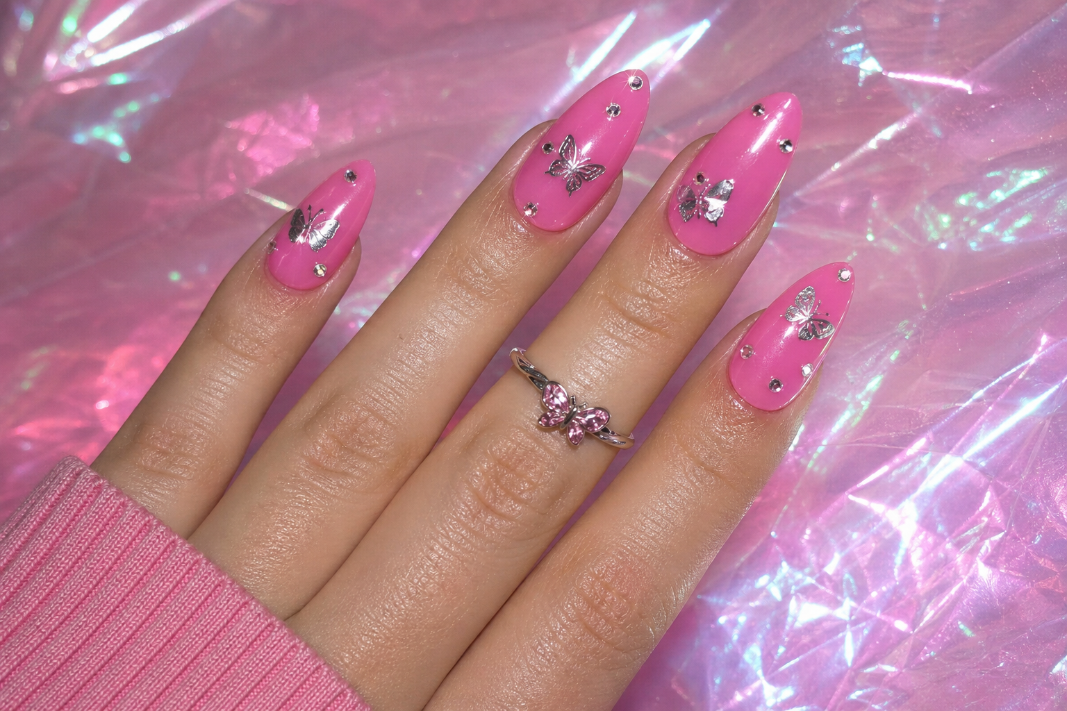 Pink Y2K nails with butterfly charms and bling