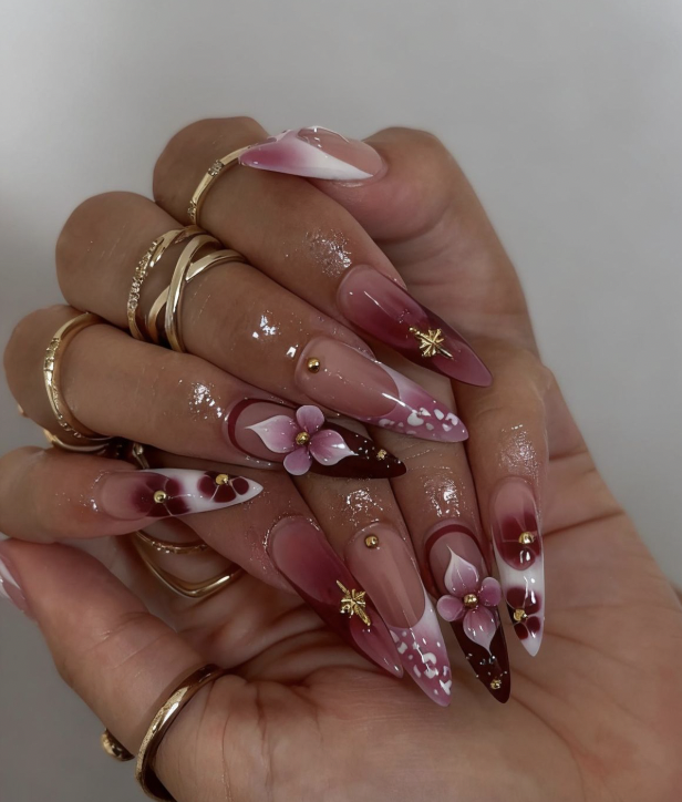 Pink stiletto nails with red flowers and gold stars