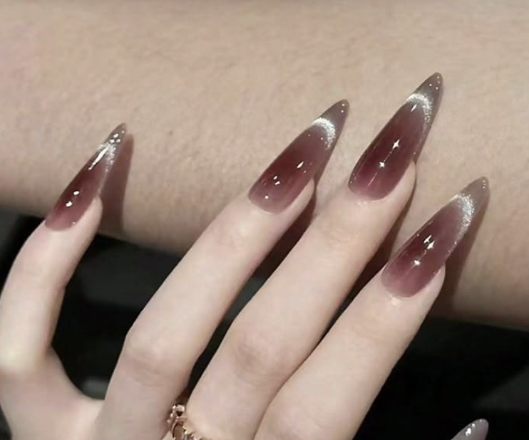 Burgundy stiletto nails with cat-eye shimmer ombre